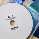 Rouleau d'étiquettes pour CD/DVD DK-11207 Brother original – Noir sur blanc, 58 mm de diamètre pour QL500